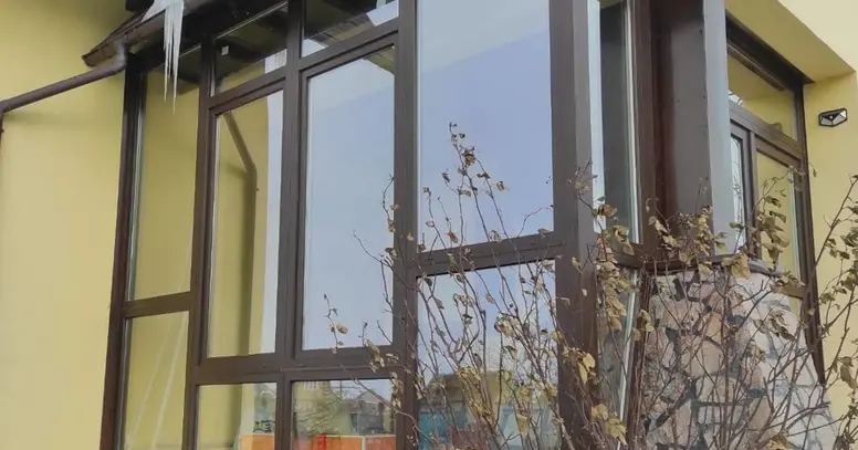 Скління тераси WDS 5S у ламінації «темний дуб» з великими світлопрозорими конструкціями.