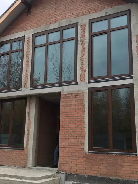 Панорамні вікна Aluplast у кольорі «горіх» для сучасного заміського будинку.