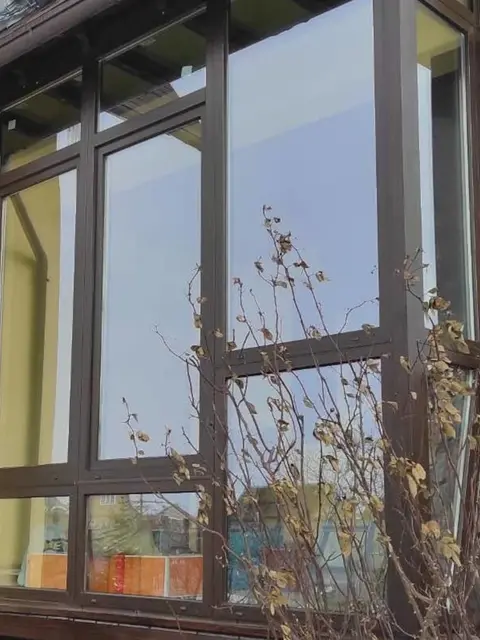 Скління тераси WDS 5S у ламінації «темний дуб» з великими світлопрозорими конструкціями.