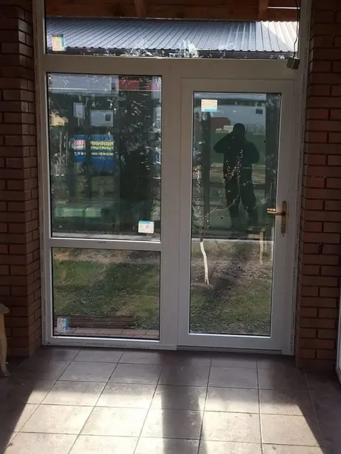 Вхідні пластикові двері у заскленій альтанці для комфортного використання протягом року.