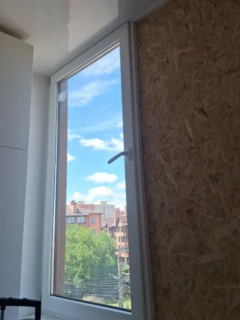 Відкривне вікно REHAU 60 у складі еркерного скління балкона зі збереженим оздобленням стелі